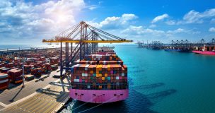 Aerial View Of Cargo Ship And Cargo Container In Harbor.